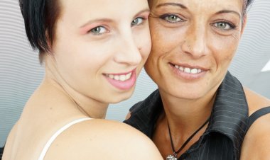 Old and young lesbian couple make out on the couch